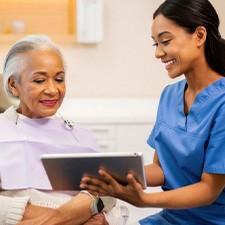 Patient and dental team member looking at tablet