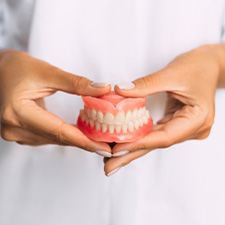 Lady presents viewer with dentures