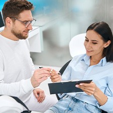 Patient filling out insurance form on clipboard