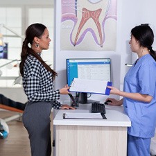 Dental team member assisting patient at front desk