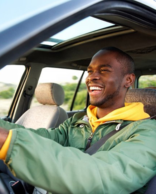Man smiles while driving