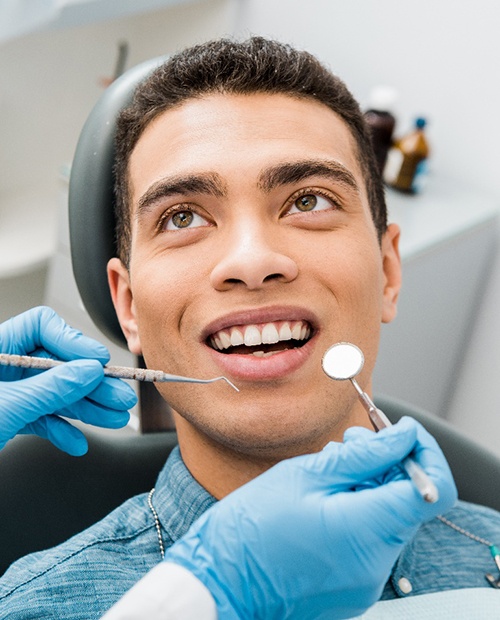 Female patient leaning back in chair for dental checkup and cleaning in Billerica, MA