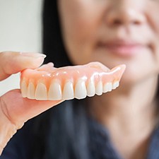 Woman holding dentures