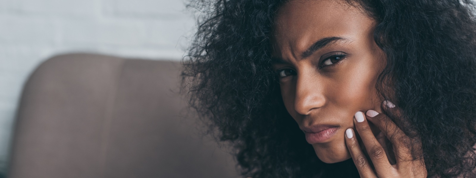 Woman in need of emergency dentistry holding jaw in pain