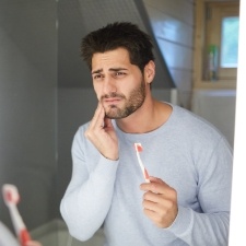 Man with toothache holding his cheek