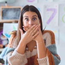 Woman with knocked out tooth covering her mouth