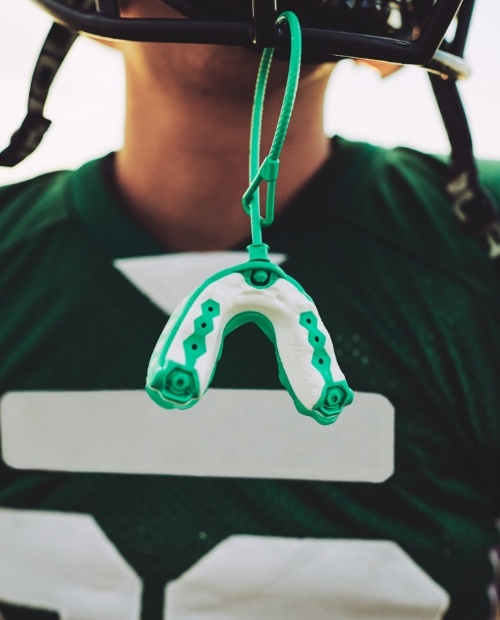 Athletic mouthguard hanging from a football helmet