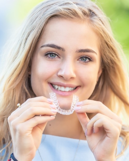 Woman placing a SureSmile aligner tray