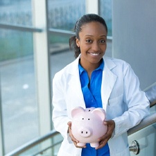 smiling dentist holding a pink piggy bank