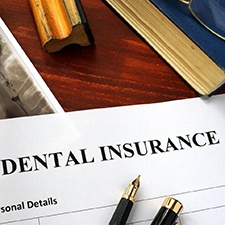 Dental insurance paperwork on brown wooden desk 