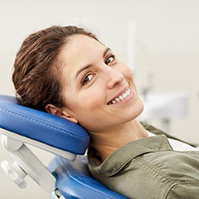 Woman in dentist’s chair smiling after Invisalign in Billerica