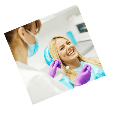 Woman in dental chair laughing with dentist