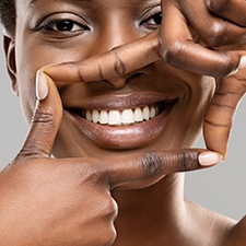 Woman framing her smile with four fingers