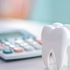 Large model tooth on desk next to calculator