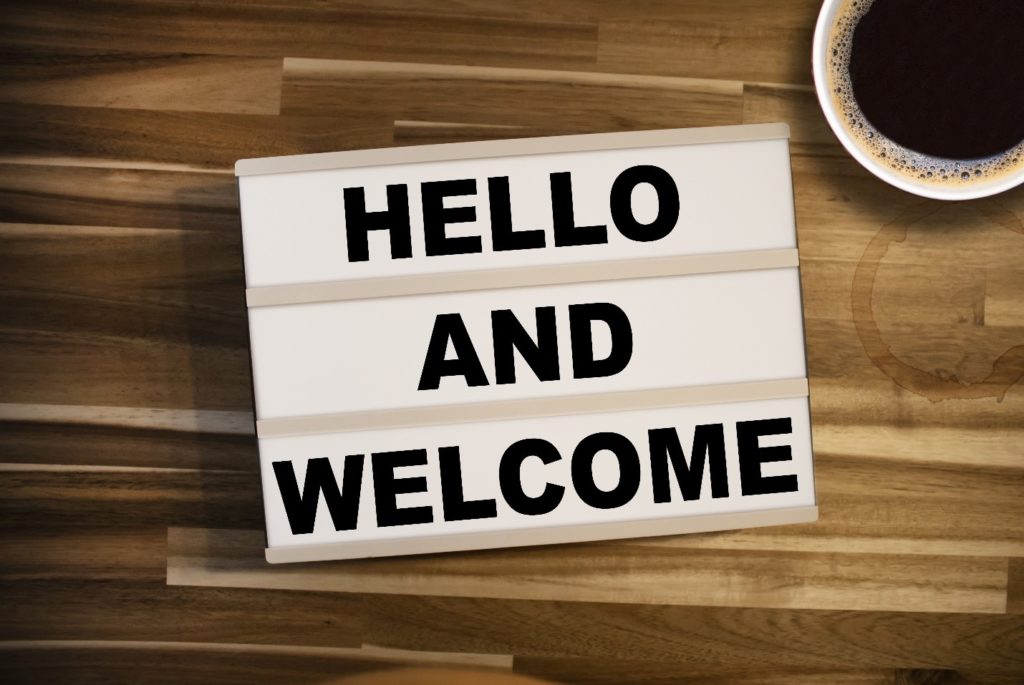 Hello and welcome sign next to coffee