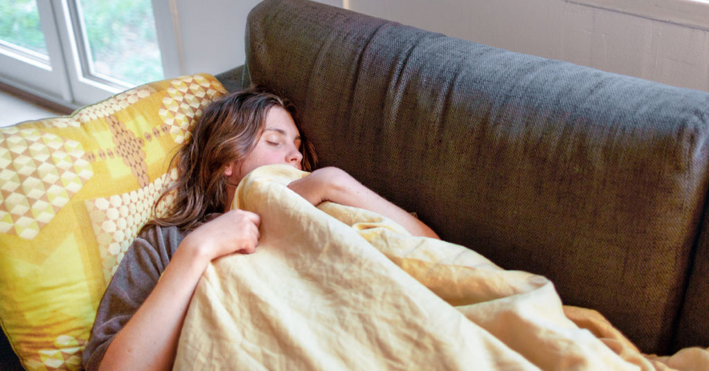 person resting on couch after getting a root canal