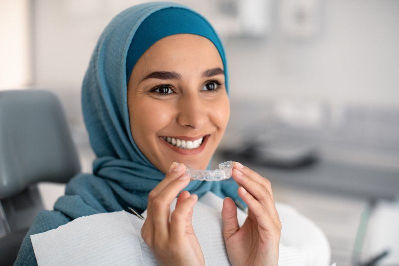 Woman smiling with her first Invisalign refinements tray
