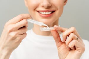Woman using take-home professional teeth whitening kit