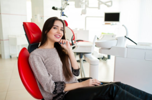 Woman smiling and tapping her chin in the patient’s chair
