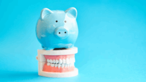 Piggy bank sitting on top of a dental model